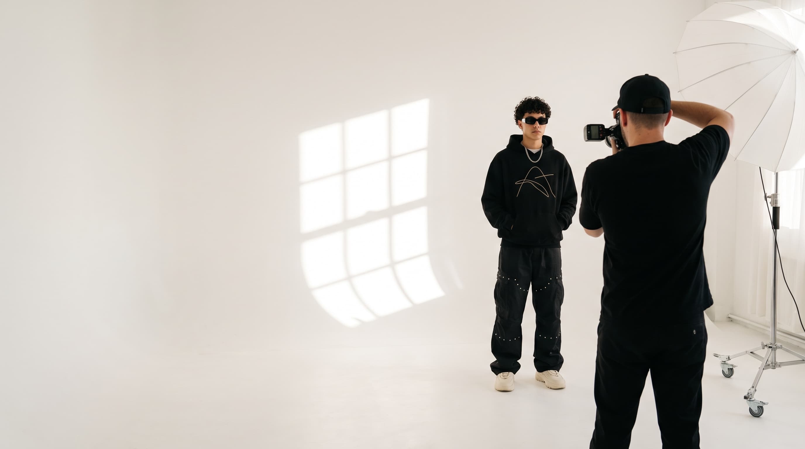 A photographer shooting a model in a white studio